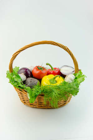 Vegetables and herbs in a wicker basketの写真素材