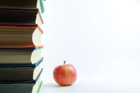 Lots of books and red apple on a white backgroundの写真素材