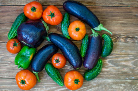 Vegetables stacked on a wooden table.