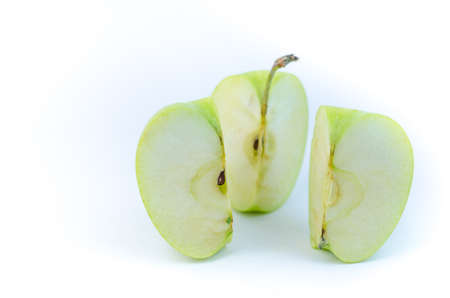 Green apple cut into slices, on a white background.の写真素材