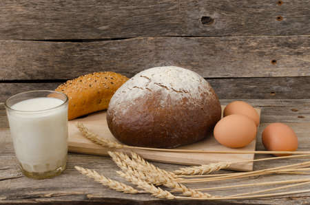 Loaf of black bread on old wooden table, the rays of the morning sunの写真素材