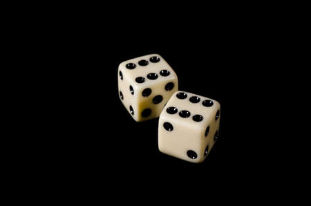 Dice beige on a black background closeup