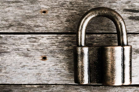 The old bronze padlock on wooden background