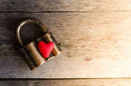 The heart of the old lock on wood backgroundの写真素材