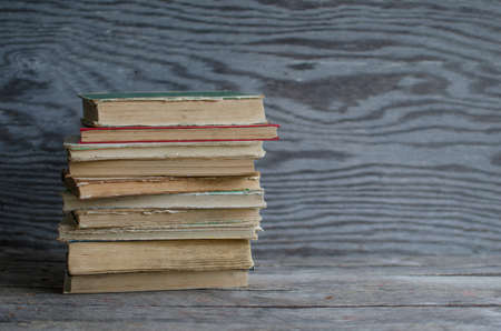 Stack old books on wooden table, wooden texture on the backgroundの写真素材