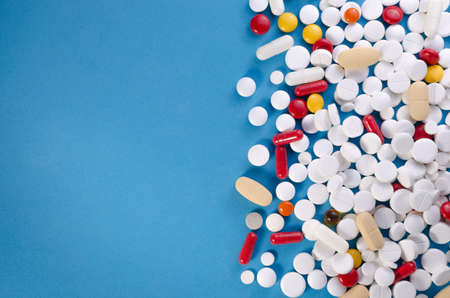 A large variety of medicinal pills on blue background