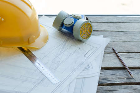 Engineering workplace, drawings, protective construction helmet and dust mask on the desktop, the view from the topの写真素材