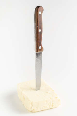 Knife in oil butter on a white background