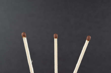Three unlit match on a dark grey backgroundの写真素材