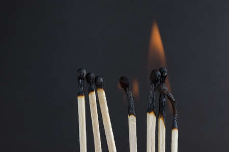 Burning matches with orange flames on a black background