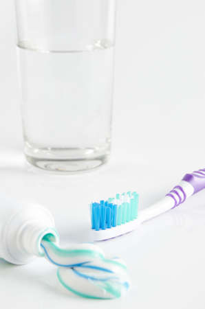Toothbrush, tube of toothpaste and a glass on a white backgroundの写真素材