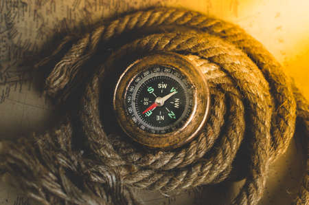Vintage old compass and rope on the background of an old map from the incident lightの写真素材