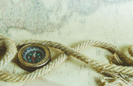 Vintage old compass and rope on the background of an old map from the incident lightの写真素材