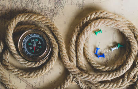 Old compass, rope and buttons on the map in the light of dayの写真素材