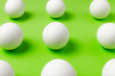 Symmetry of white eggs on bright light green background. Abstraction.