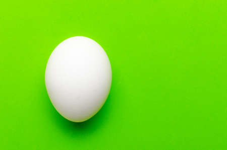 White egg on a bright green background.Close up.の写真素材
