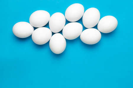 White chicken eggs the shape of clouds on bright blue background.Sky.
