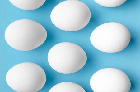 White chicken eggs on blue background.Close upの写真素材