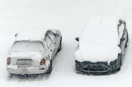 Cars were covered with a thick layer of snow during heavy snowfall, snow storm.の写真素材