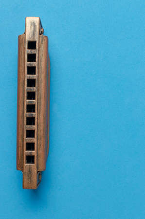 Old harmonica on a blue background.の写真素材