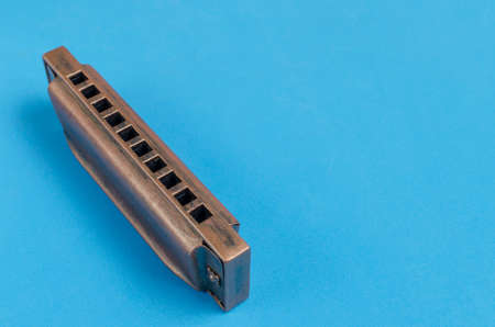 Old harmonica on a blue background.の写真素材