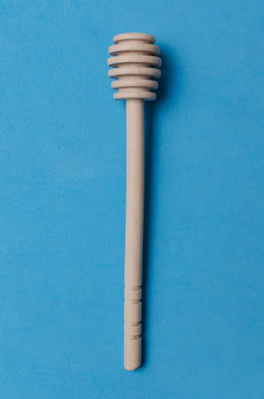 Stick to honey on blue background.Close up.の写真素材