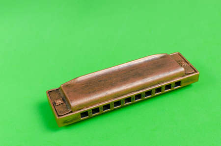 Old harmonica on a green background.Musical instrument.の写真素材