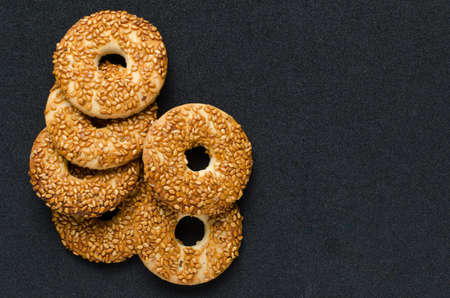 Round cookies with sesame seeds on a black background.の写真素材