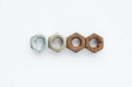 The new and the old rusty nuts on a white background. Metal corrosion.の写真素材