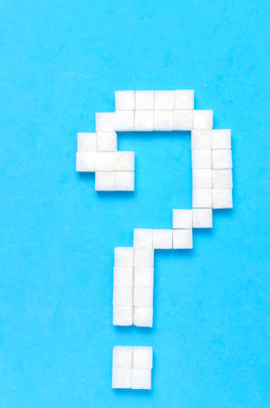 Refined sugar in the form of a question mark on a blue background.The concept of sweet life.の写真素材