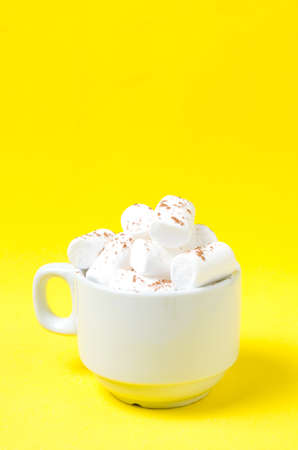 White marshmallows in a coffee mug on a bright yellow background.Place under the text.の写真素材