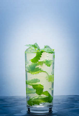 Cool water in a glass of ice and mint petals.Soft drink.の写真素材