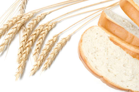 Slices of sliced bread and wheat on a white background close-up.の写真素材
