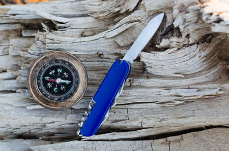 Compass and a knife for survival on an old dried tree,Close up.の写真素材