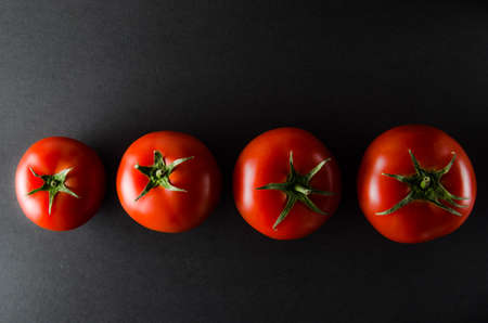 Bright, ripe tomatoes on a black background.Healthy vegetables.