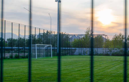 Football field with green lawn at sunset.Sports and team play.Over the fence.の写真素材