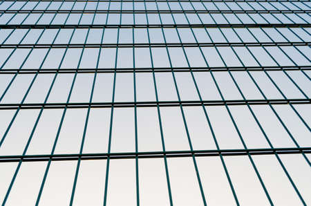 Metal mesh fence, fence on blue sky background.Rectangular abstraction close-up.