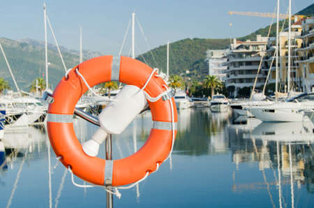Orange lifebuoy in the port on background of yachts and boats.On a bright Sunny day.の写真素材