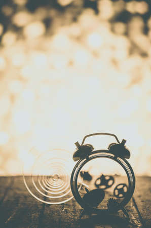 Broken alarm clock with springs and gears scattered on the background of bright light.の写真素材