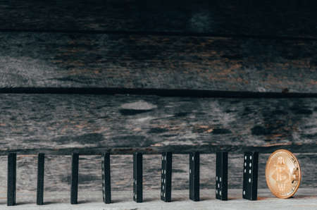 Domino and bitcoin coin on wooden background. Crash, Finance, inflation.の写真素材