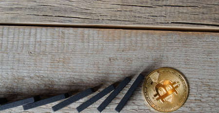 Dominoes fall on the bitcoin coin.の写真素材