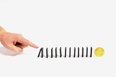Human hand pushing dominoes on the bitcoin on a white background.
