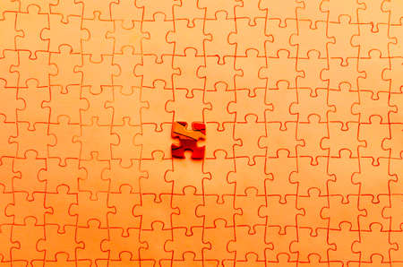 Assembled puzzle on red background, highlight one red cells of puzzle.