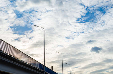 Car bridge and mast lighting on the background of beautiful blue sky and clouds.の写真素材