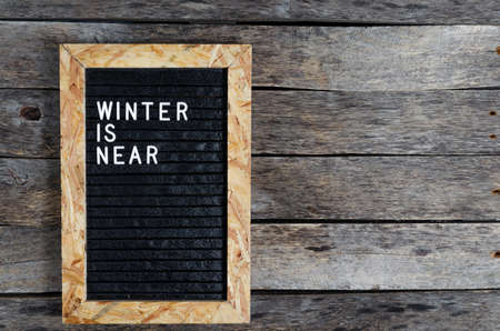 Letter board with white lettering winter is coming on old wooden background.の写真素材