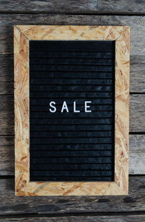 Letter board with white lettering sale.On an old wooden background.の写真素材