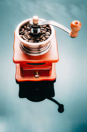 Coffee grinder with coffee beans on the reflective surface. Making coffee.の写真素材