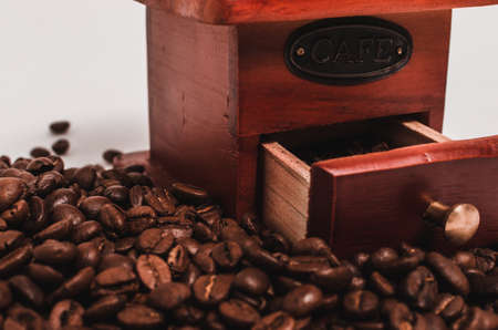 Retro wooden coffee grinder on white background with coffee beans.の写真素材