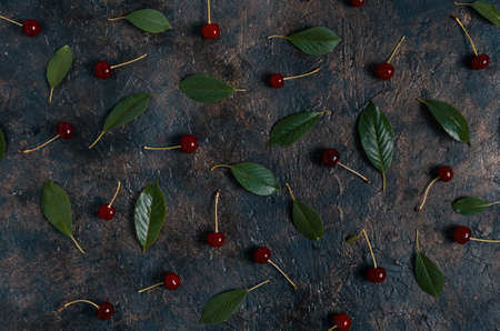 Ripe, bright cherry with green leaves on an old, rustic stone background with a view from the top.の写真素材