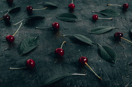 Cherry berries with leaves on the old, rustic concrete floor.の写真素材